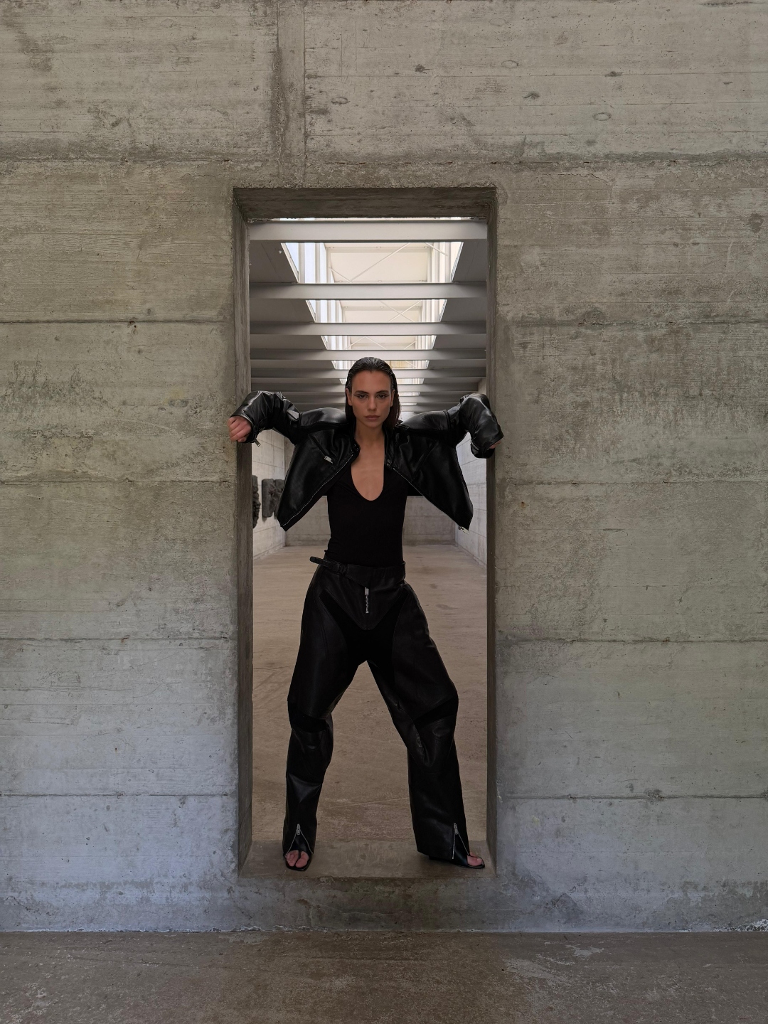 Figure in leather framed in a concrete doorway.