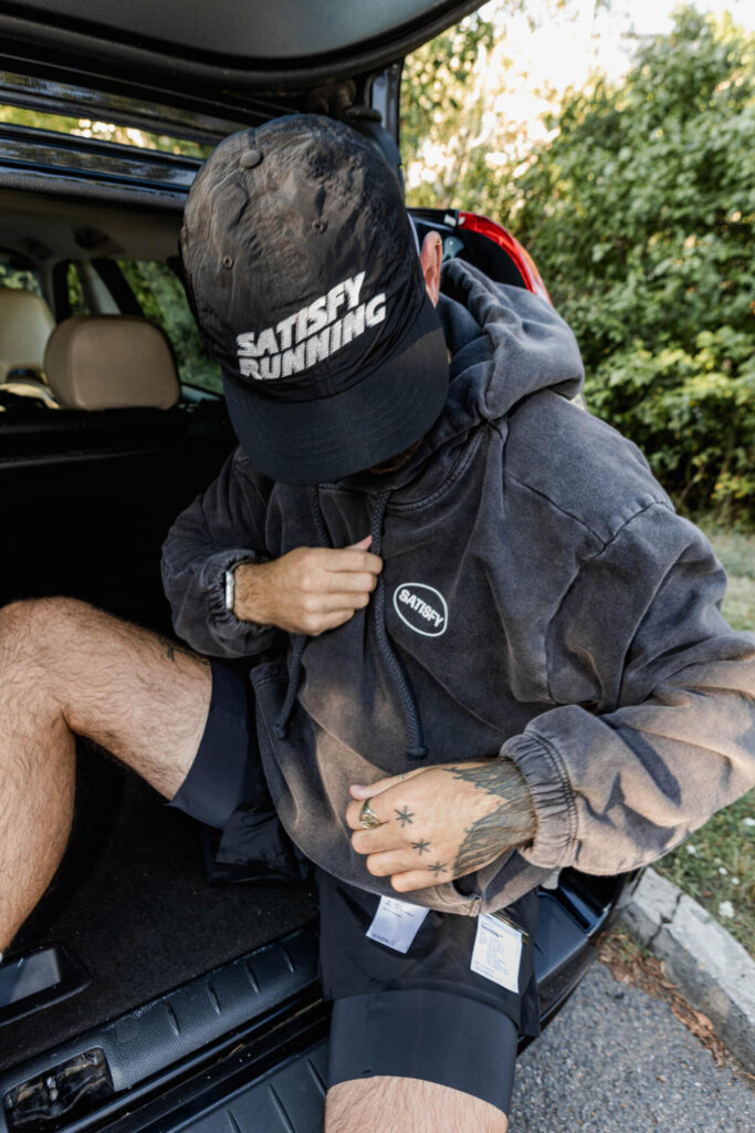 Travel Build — Satisfy Running cap at car